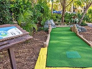 A miniature golf course with a wooden sign indicating hole 13 and par 2. - Turtle Beach Family Resort | Water Park, 5 Pools, Sleeps 5 (Mermaid Beach)
