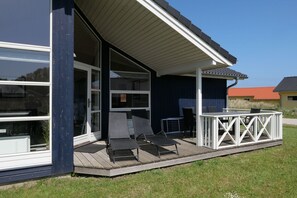 A modern house with a deck, outdoor seating, and a large sliding glass door. - Ostsee-ferienparadies fur 8 Personen (Grossenbrode)