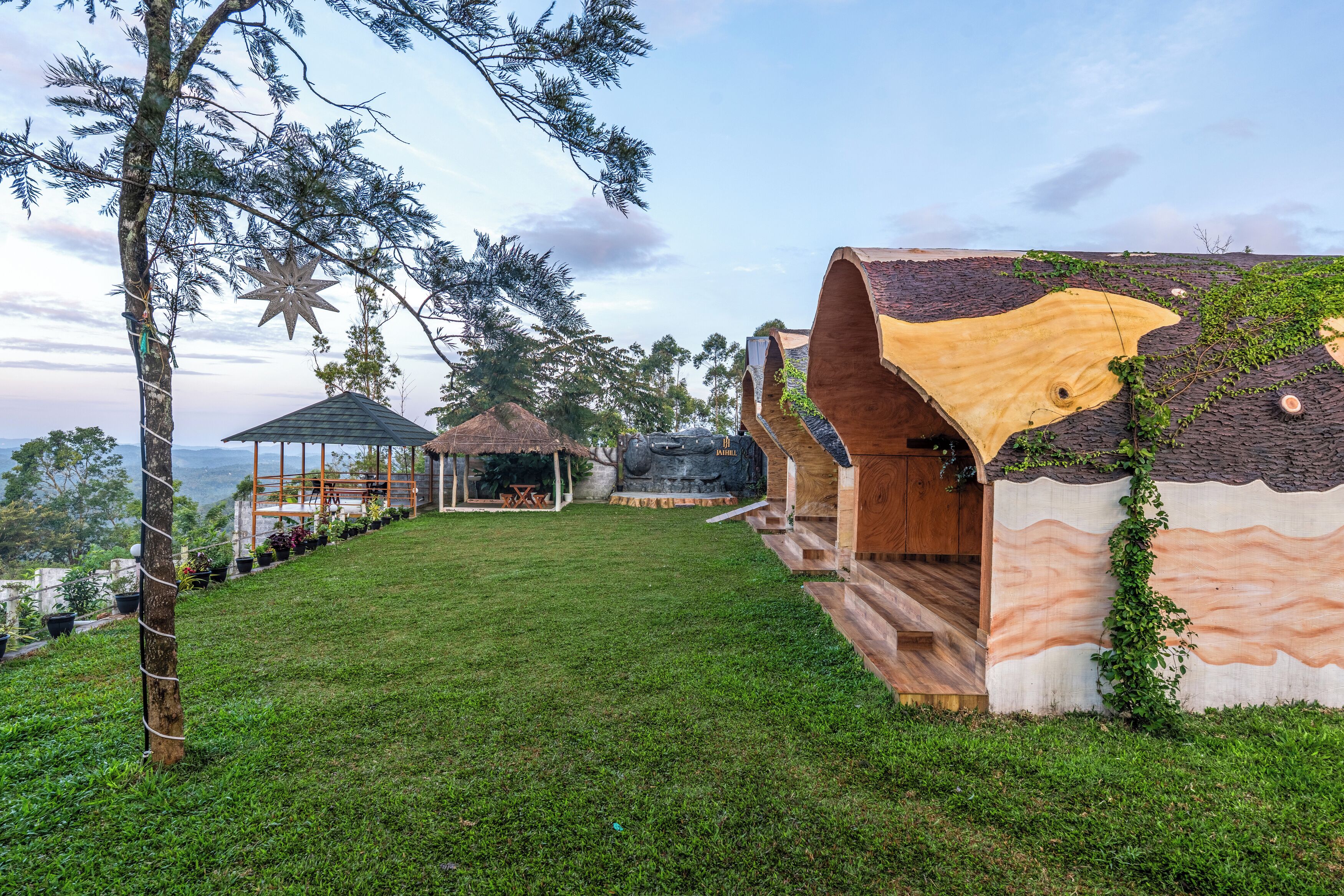 Ein Resort mit Holzhütten, einem Pavillon und einer Rasenfläche.