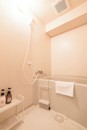 Bañera con ducha, secador de pelo, pantuflas, toallas