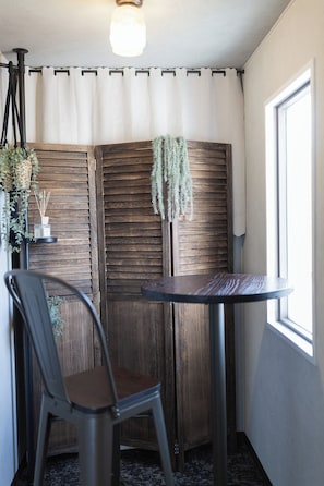 A corner room with a wooden partition, a round table, a chair, and a window. - b&Dotonbori 2 (Chuo Ward)