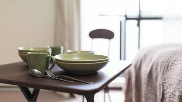 Una mesa de comedor con cuencos verdes, una cuchara y un tenedor.