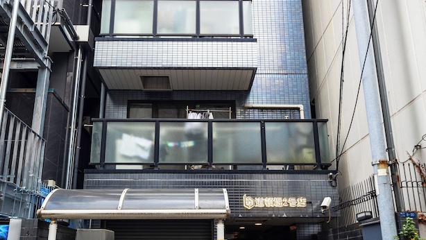 Un edificio de varios pisos con un local comercial en la planta baja.