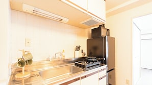 Una cocina con un lavaplatos de acero inoxidable, una estufa y un refrigerador.