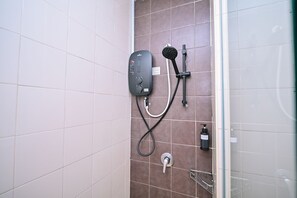 A bathroom with a shower unit, a handheld showerhead, a bottle of shampoo, and a towel rack. - Kingston Hotel 11 @ PWTC, KL (Kuala Lumpur)