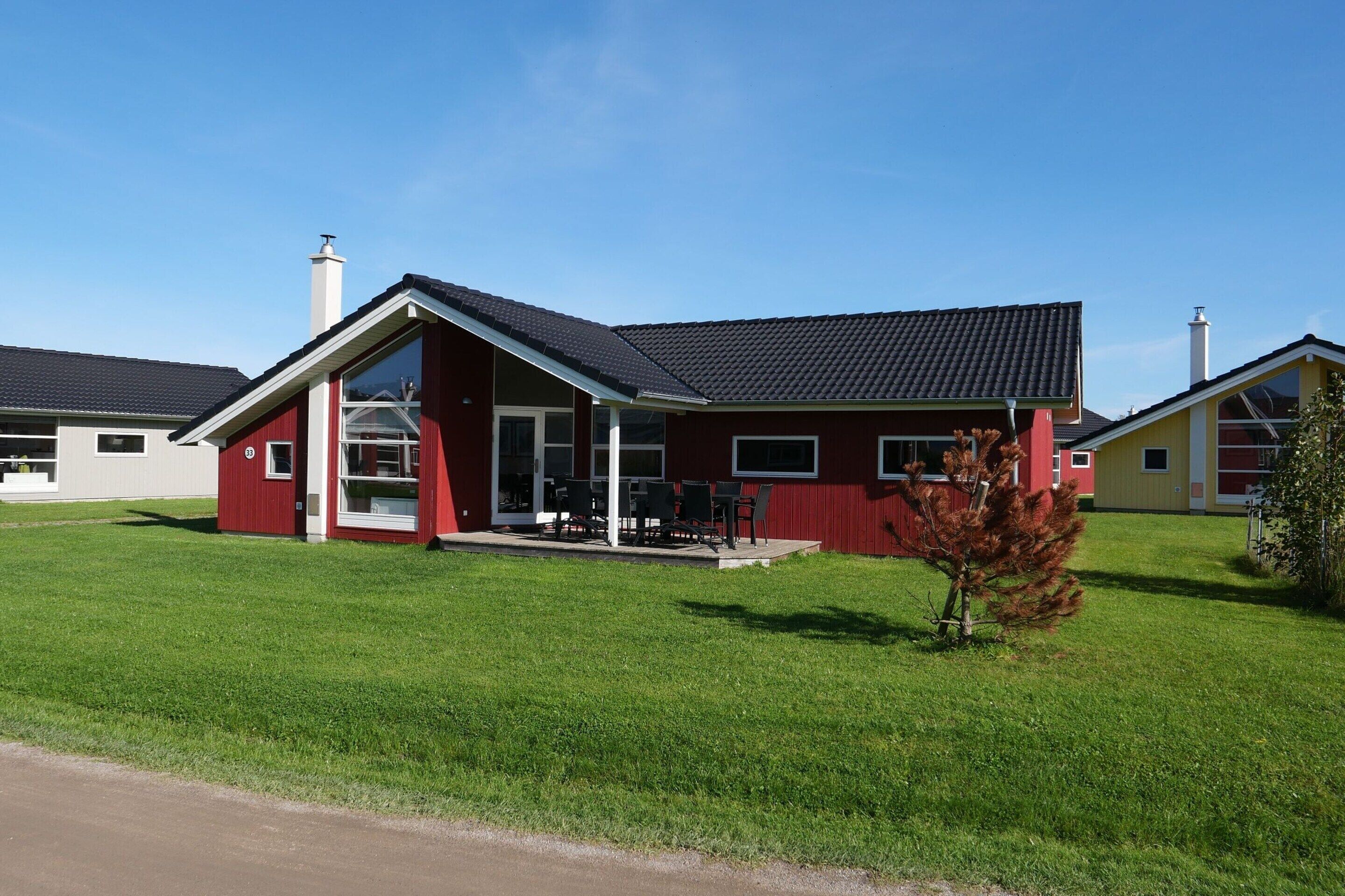 Ein rotes Gebäude mit einer überdachten Terrasse und blauem Himmel.