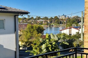 A residential area with a river, houses, and a balcony with plants. - Peaceful 1BDR Private Stay in Chiswick (Chiswick)