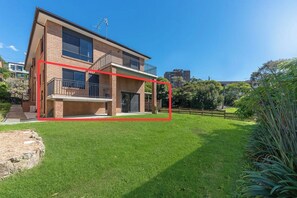 A two-story residential building with a balcony, a paved driveway, and a well-maintained lawn. - Peaceful 1BDR Private Stay in Chiswick (Chiswick)