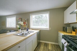 A compact kitchen with a sink, stove, and microwave. - Walk to Ski Lifts! Apt in Heart of Red River (Red River)