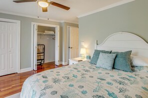 Ein Schlafzimmer mit Bett, Kleiderschrank, Nachttisch und Deckenventilator.