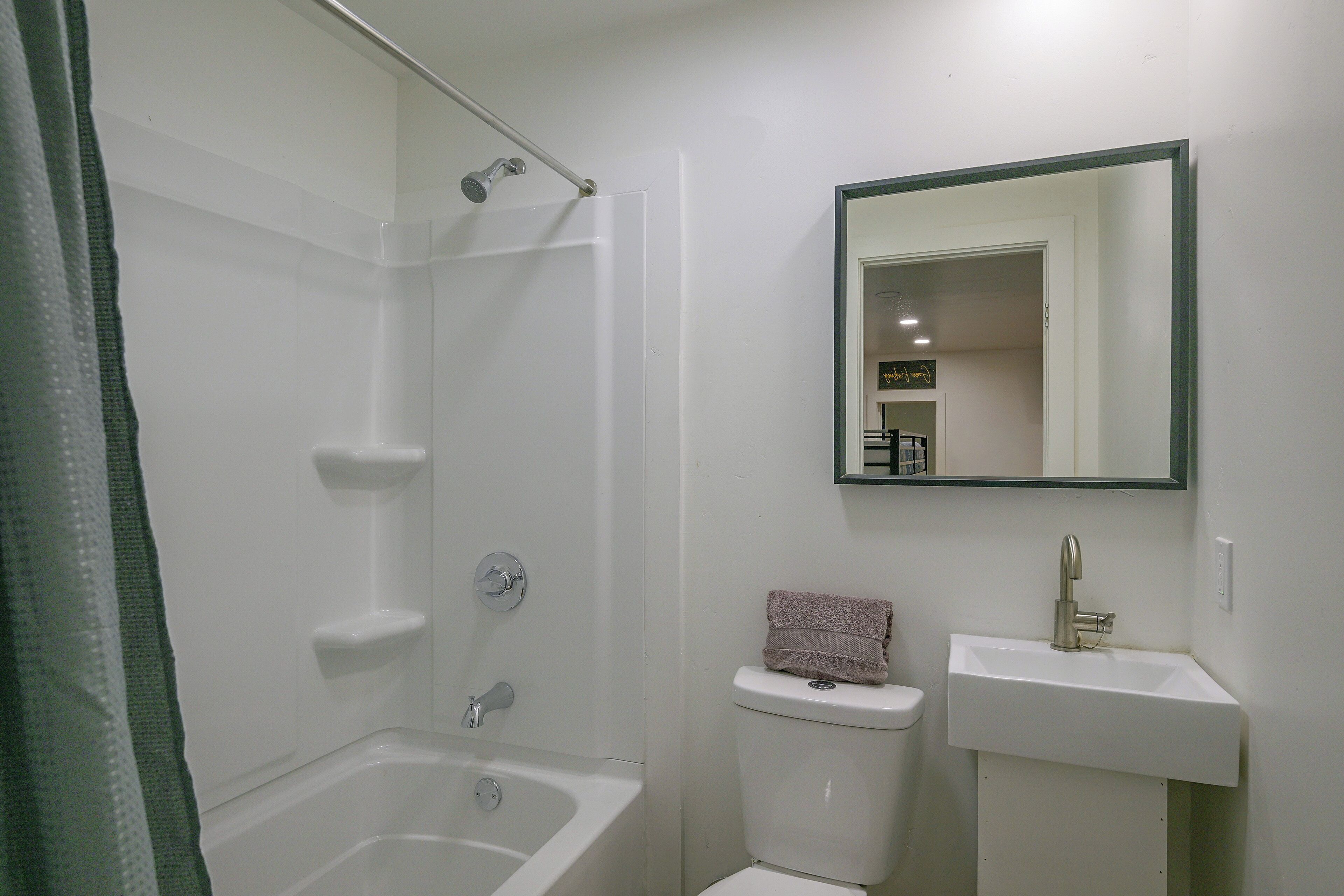 Un bagno con una vasca, una doccia, un water e un lavandino.