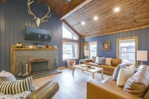 A cozy living room with a fireplace, leather sofas, and a mounted deer skull. - Walk to Main St: Red River Lodge w/ Ski Views! (Red River)