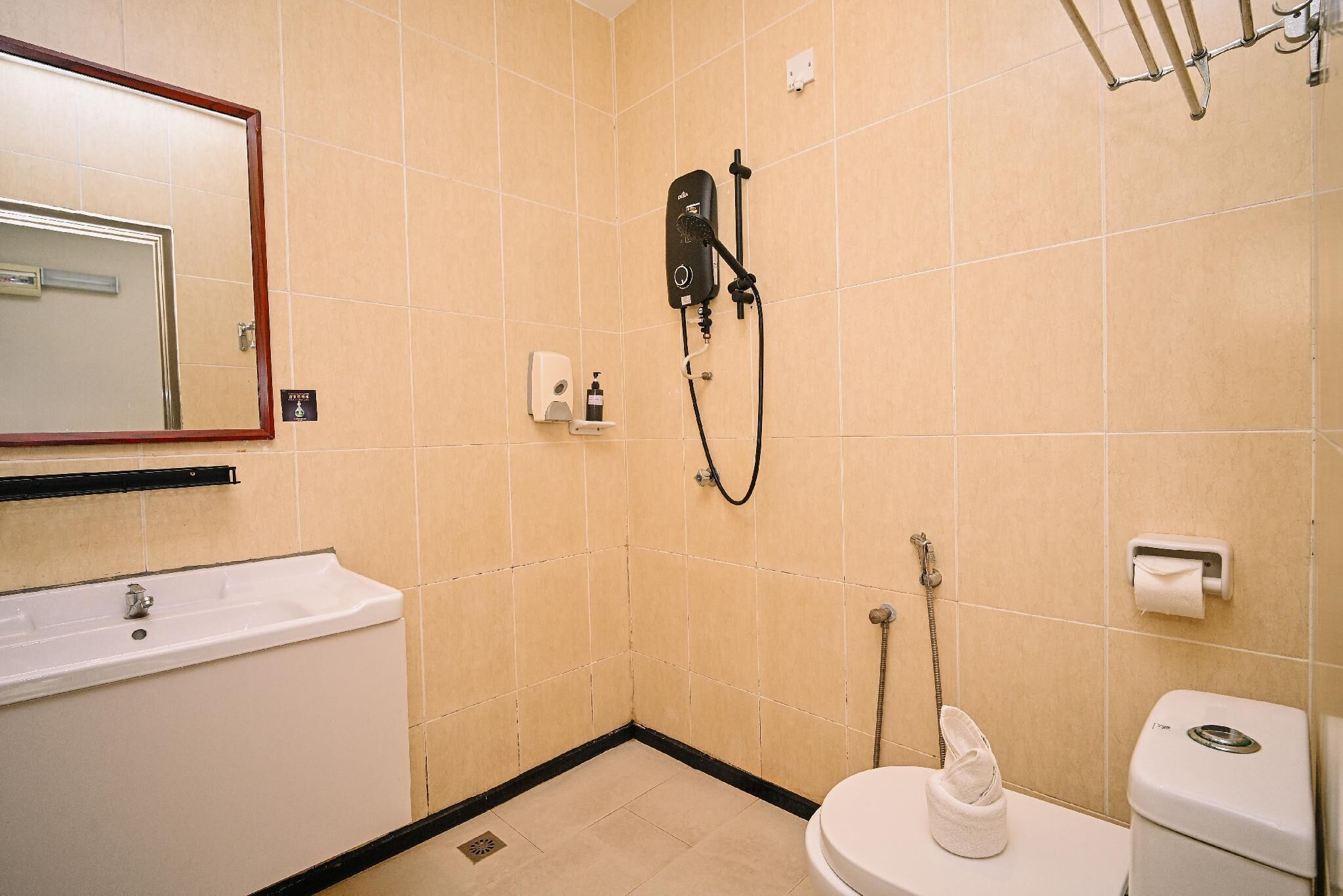 A small bathroom with a sink, toilet, and shower.