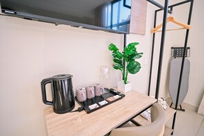 Una kitchenette con cafetera, tazas de té y una bandeja con bolsitas de té.