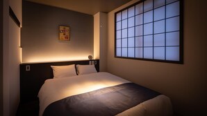 Una habitación de hotel con una cama, un reloj de pared y un panel shoji.