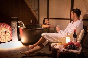 A couple relaxing in a hot tub with a wooden floor, a decorative umbrella, and a fruit platter with a bottle of wine. - Imakusa-so, Osaka, Dotonbori - Goyakuya - (大阪市中央区道頓堀１丁目東)