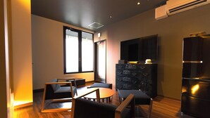 Una sala de estar moderna con televisor de pantalla plana, un mueble de madera y un comedor con sillas y una mesa.
