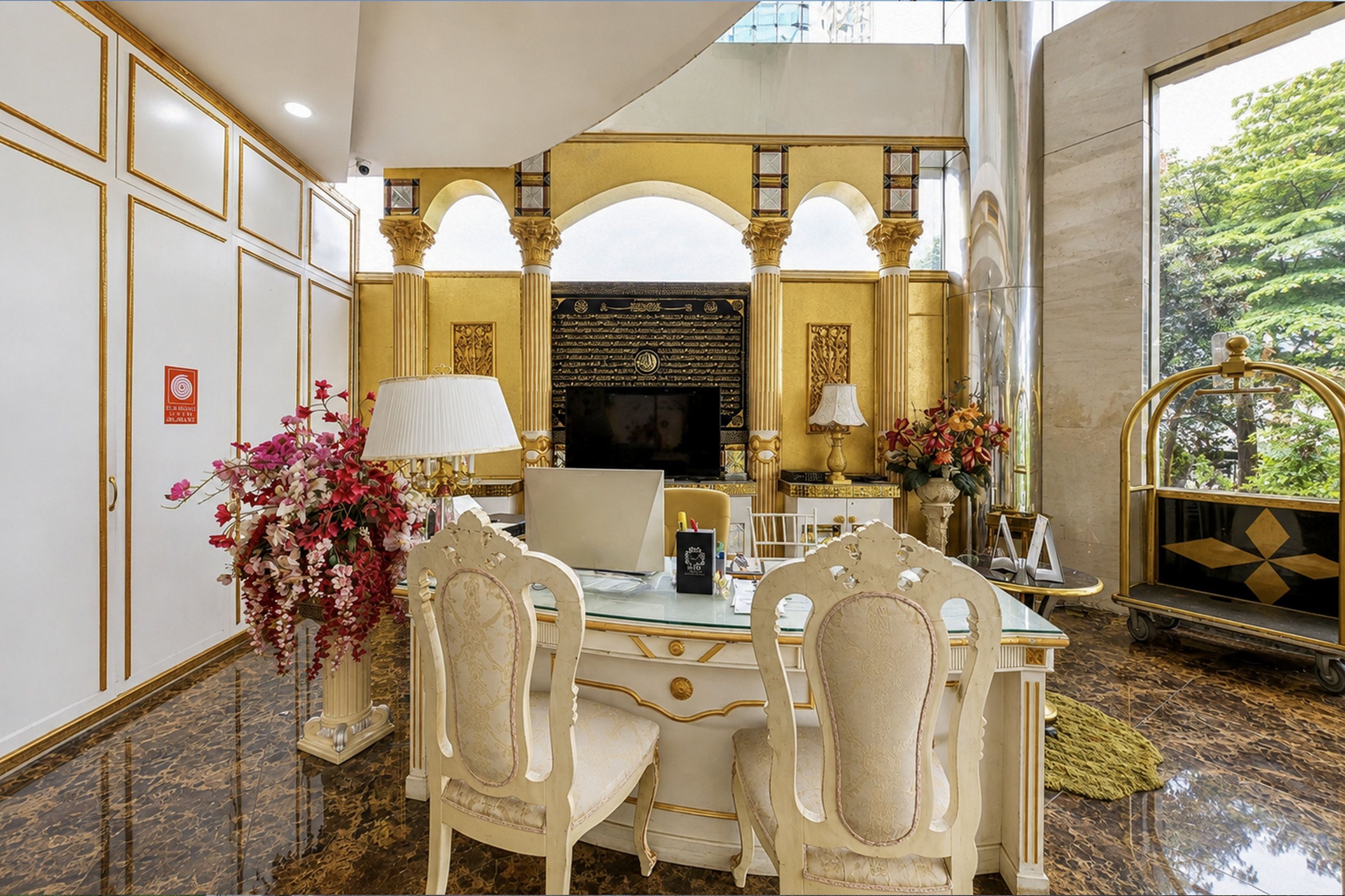 A luxurious room with a marble floor, a large desk with two chairs, a television, and a decorative wall with arches.
