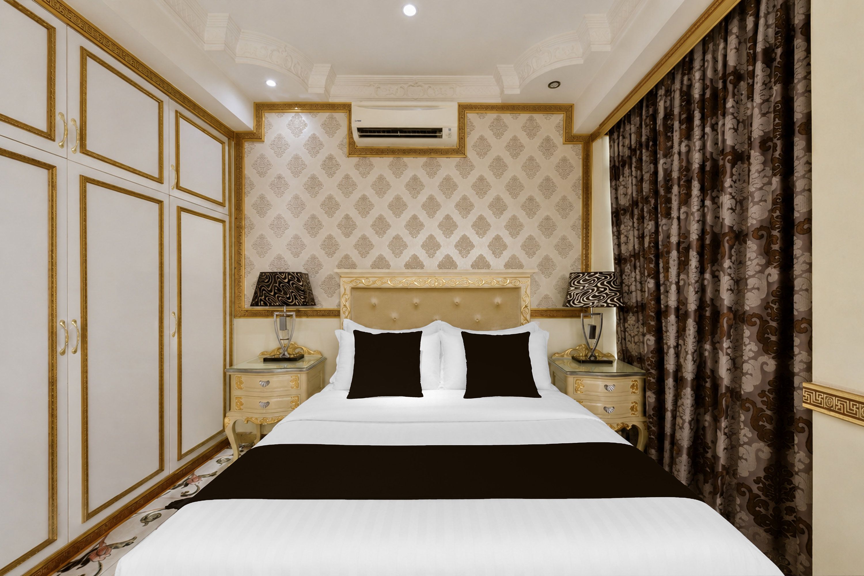 Habitación de hotel con una cama grande, dos mesitas de noche, cabecera y un amplio ventanal con cortinas.