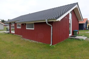 Punainen rakennus, jossa on kalteva katto, ikkuna ja ovi.