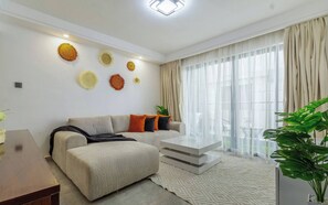 A modern living room with a sofa, coffee table, and decorative wall art. - Cozy Nest 1BR Kilimani (Nairobi)