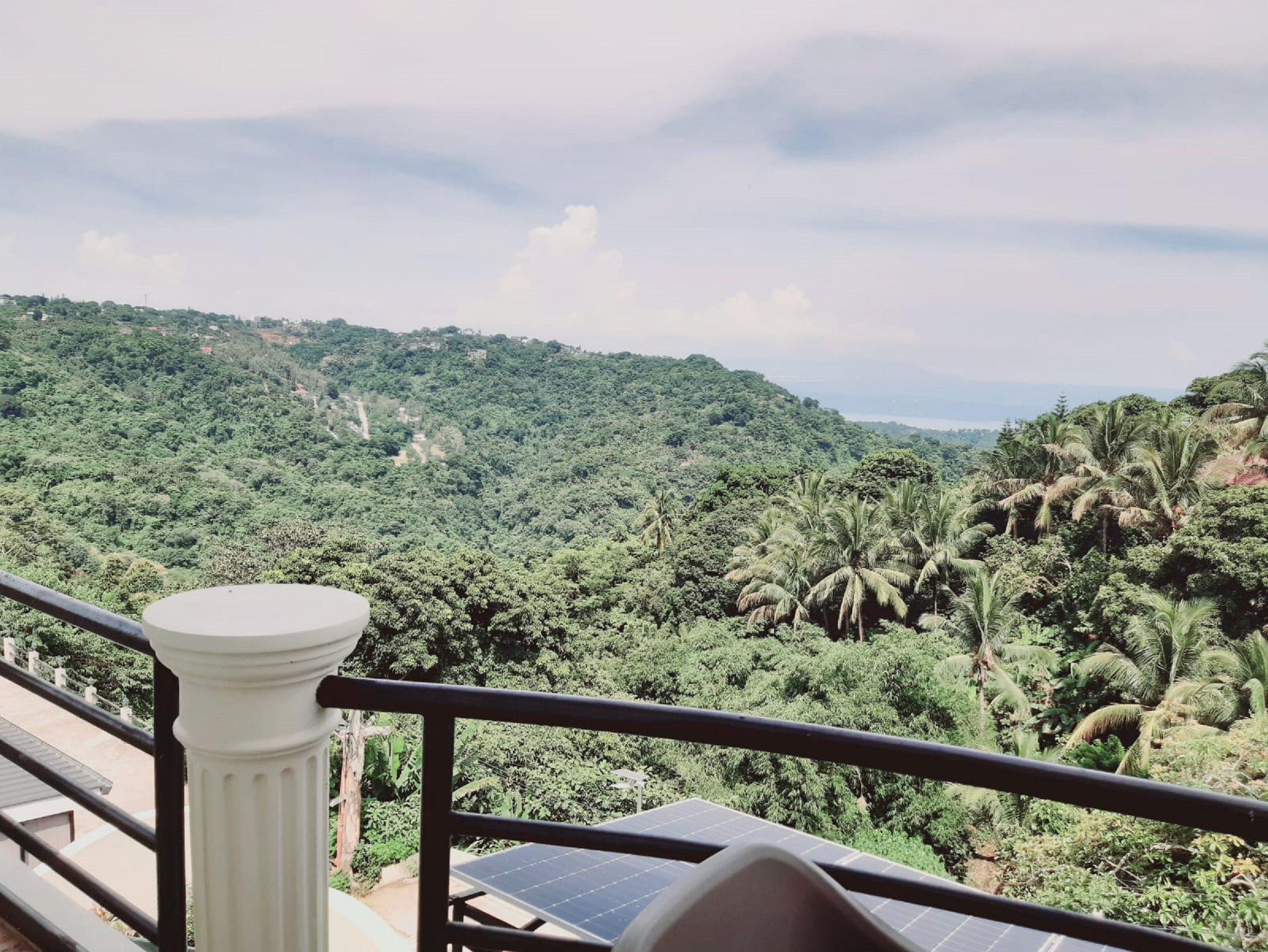 A balcony with a view of a lush green landscape and solar panels.