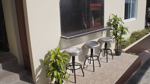 A patio area with a seating arrangement and a window overlooking a street.
