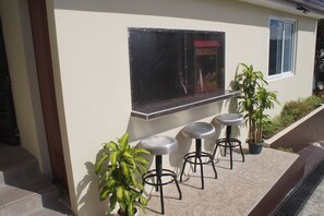 A patio area with a seating arrangement and a window overlooking a street.