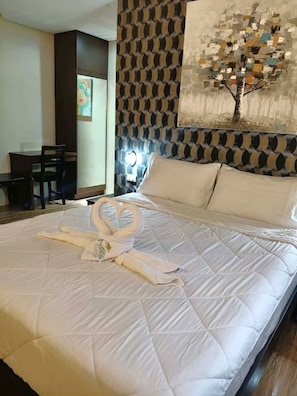 A hotel room with a bed, a desk, and a chair.
