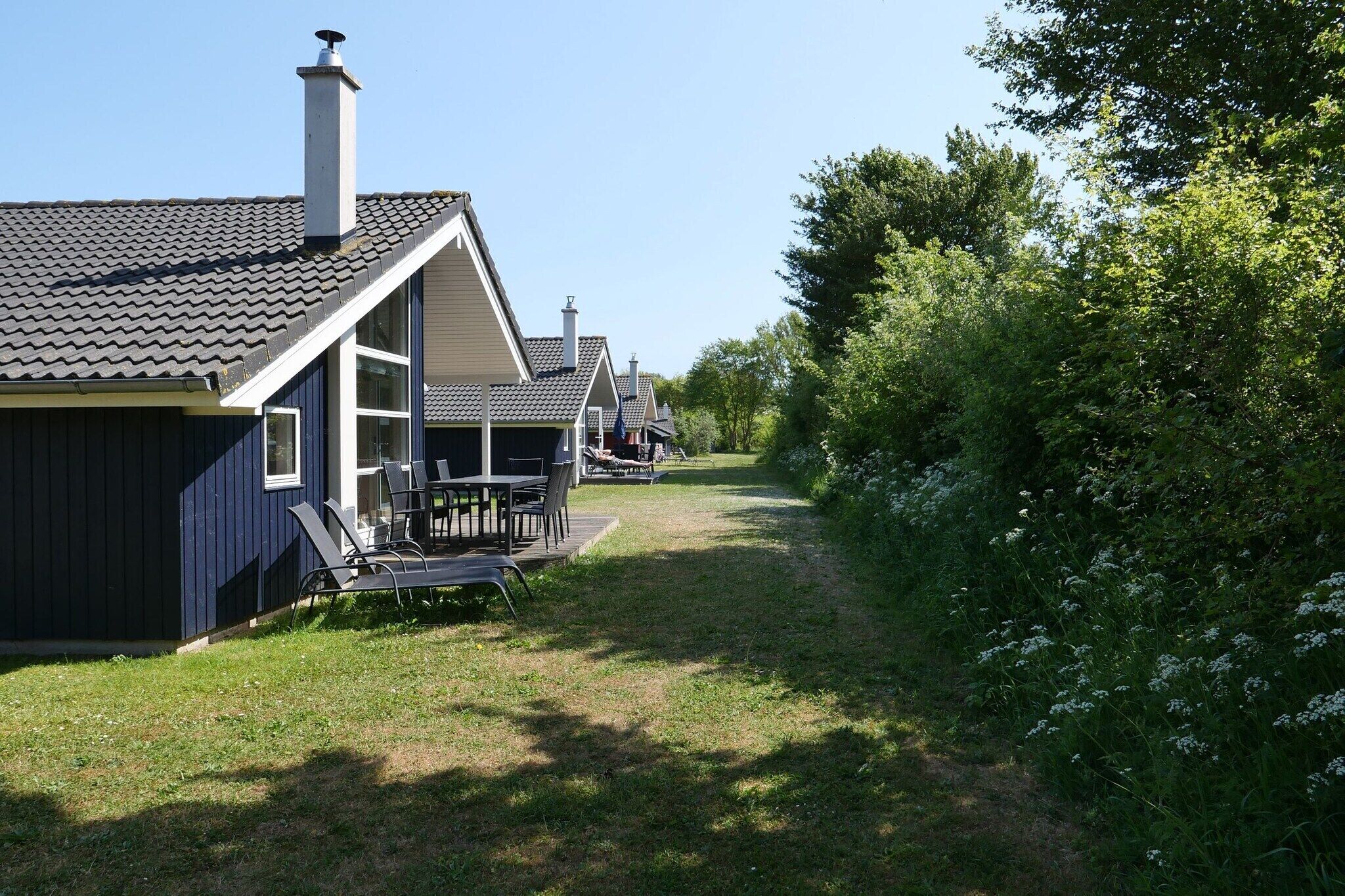 A row of cabins with attached porches, surrounded by greenery.
