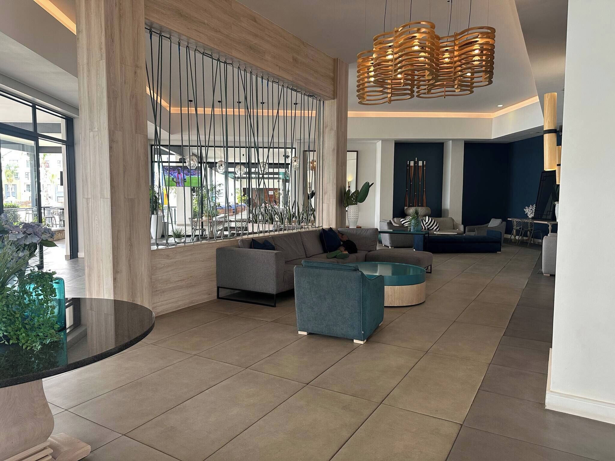 Eine geräumige Lobby mit einer Sitzecke, einem großen Fenster und einem modernen Kronleuchter.