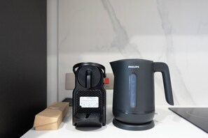 A coffee maker and a water boiler on a countertop. - Bloomfields Studio in Fairways 1 -YGC (Abu Dhabi)