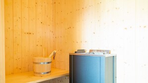 Uma sala de sauna com paredes de madeira, um banco de madeira e um banco de sauna azul.