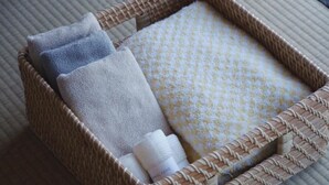 Un panier en osier contenant des serviettes pliées et une bouteille.