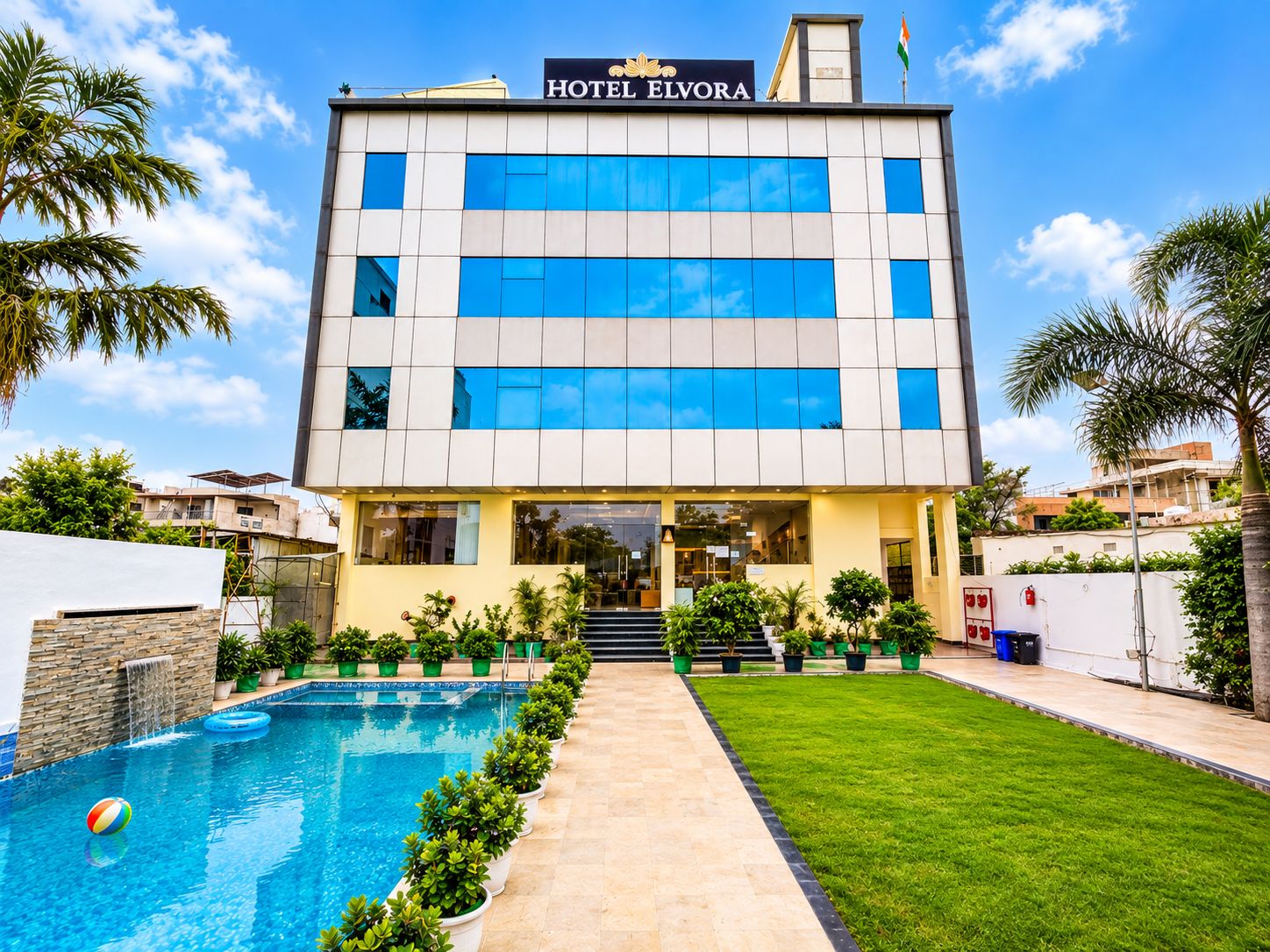 Um moderno edifício de hotel com piscina e um gramado bem cuidado.