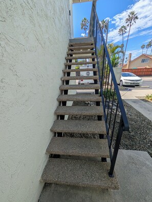 A concrete staircase with metal railings leading to a building entrance.