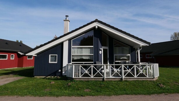 A small, single-story house with a gabled roof and a front porch. - Nordisches Haus mit Sauna und Kamin (Grossenbrode)