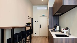 Una cocina moderna con encimera de madera, un fregadero y una zona de comedor con sillas.