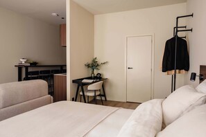 A hotel room with a bed, a desk, a chair, a wardrobe, and a door. - RAIBU ANTWERP Diamond District (Antwerp)