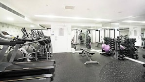 A gym with treadmills, weight machines, and free weights.