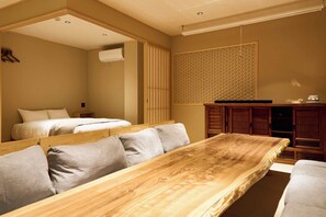 A room with a wooden dining table, two beds, a wardrobe, and a patterned wall. - Imakusa-so, Osaka: Tempozan - Ikisu - (大阪府大阪市港区築港3丁目10−11)