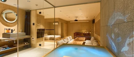 A modern spa room with a glass-enclosed hot tub, a wooden bench, and a massage table.