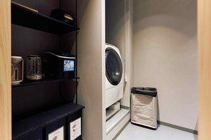 A laundry area with a washing machine, a trash bin, and a coffee maker on a shelf. - Imakusa-so, Osaka: Tempozan - Ikisu - (大阪府大阪市港区築港3丁目10−11)