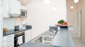 Una cucina moderna con forno integrato, microonde e macchina del caffè.