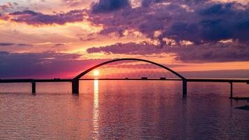 A bridge over water with a sunset in the background.