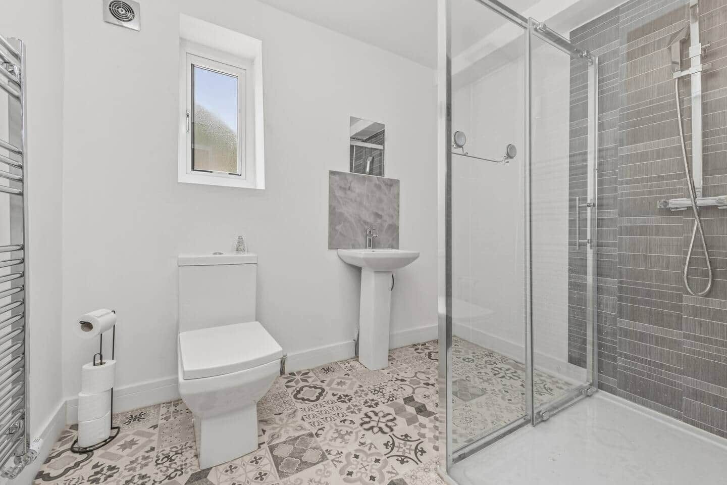 Une salle de bain comprenant des toilettes, un lavabo et un espace douche.