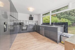 A modern kitchen with stainless steel appliances, a built-in oven, and a dishwasher. - Victoria Suite - Huddersfield Suite 2 (Huddersfield)