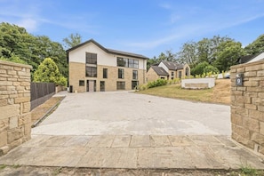 A residential building with a paved driveway, stone walls, and a clear sky. - Victoria Suite - Huddersfield Suite 2 (Huddersfield)