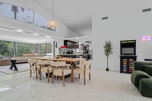 A modern kitchen with dark cabinets, a microwave, and a coffee machine. - Waterfront House with Tiki & Firepit (Miami)