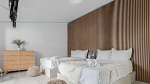 A modern bedroom with a large bed, bedside tables, a wooden wardrobe, and a potted plant. - Waterfront House with Tiki & Firepit (Miami)